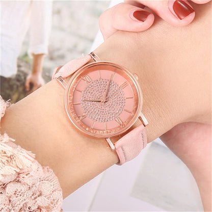 Rose gold women's quartz wrist watch with stainless steel dial, leather strap, Roman numerals, and minimalist design.