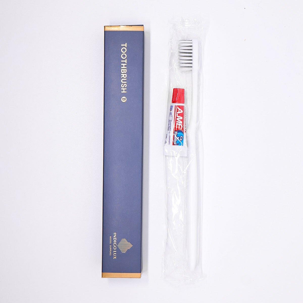 Set of 50 Hlpmedical toothbrushes and toothpaste tubes for guesthouse travel oral care, displayed in a neat arrangement.