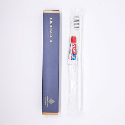 Set of 50 Hlpmedical toothbrushes and toothpaste tubes for guesthouse travel oral care, displayed in a neat arrangement.