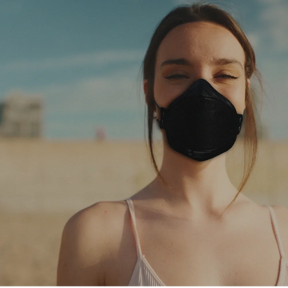 Woman smiling wearing a black Hlpmedical Trident Project 3 FFP3 respirator mask for respiratory protection.